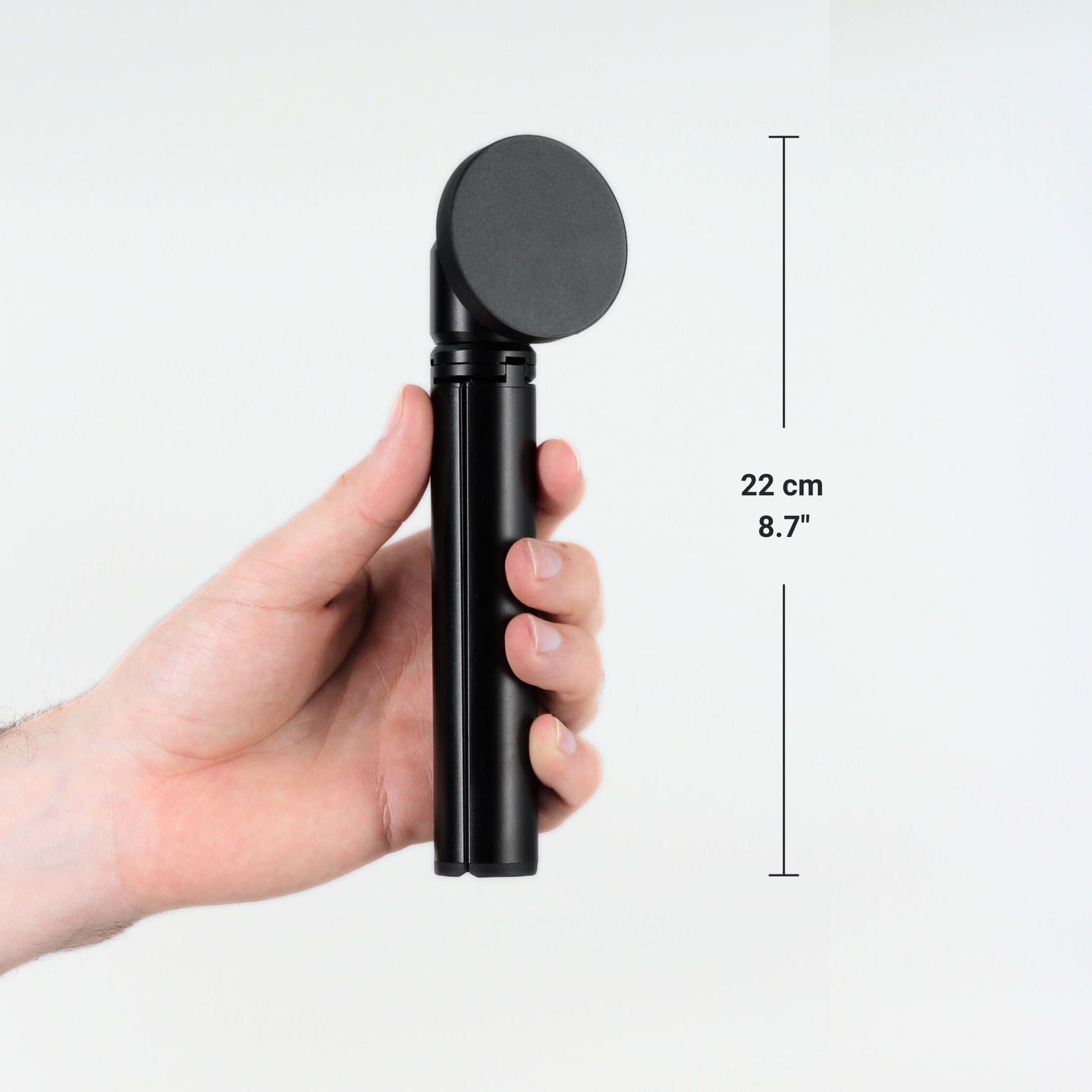 FLEXSTA portable monitor stand folded and held in one hand, showing compact size of 22cm (8.7 inches)