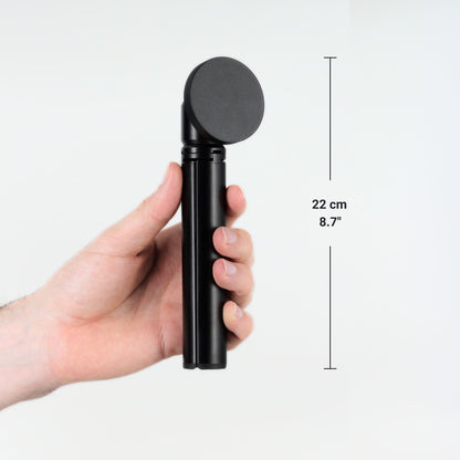 FLEXSTA portable monitor stand folded and held in one hand, showing compact size of 22cm (8.7 inches)